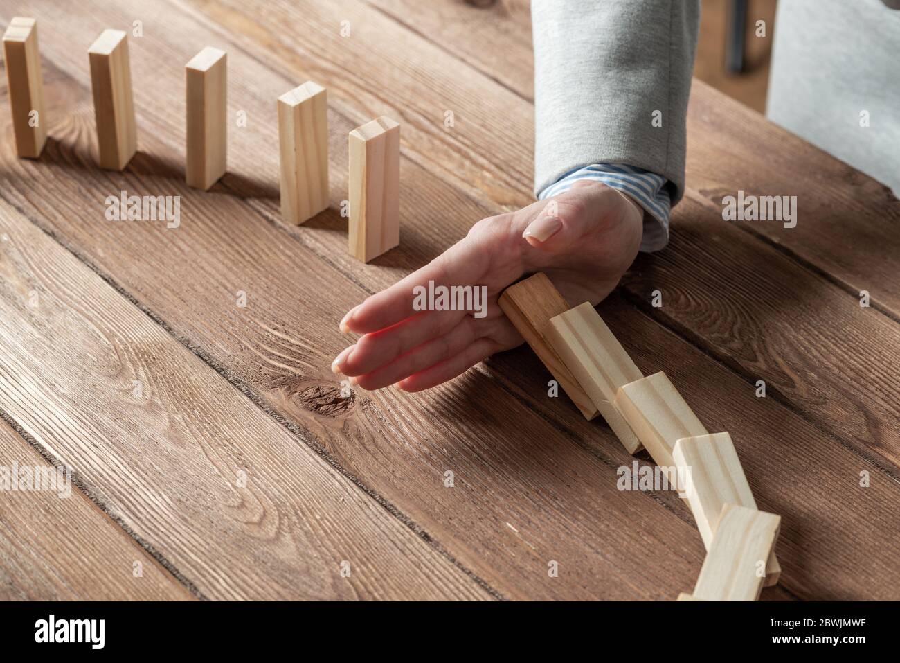 Donna business mano stop effetto domino Foto Stock