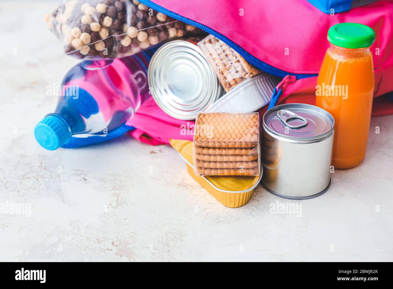 Borsa con diversi prodotti su sfondo chiaro. Concetto di programma alimentare zaino Foto Stock