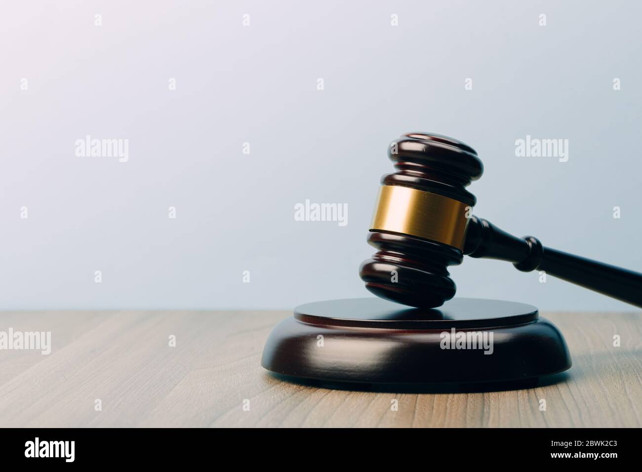 Simbolo di legge e giustizia su un tavolo di legno e sfondo blu nell'ufficio legale Foto Stock