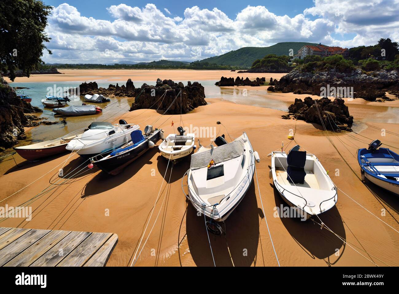 Barche che si trovano nella sabbia in spiaggia con bassa marea Foto Stock