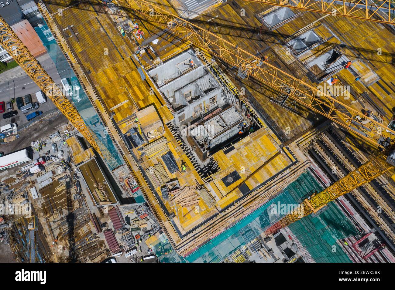 Sito di costruzione dall'alto. Vista aerea del nuovo appartamento in costruzione. Persone che lavorano. Vista dall'alto zona industriale. Foto Stock