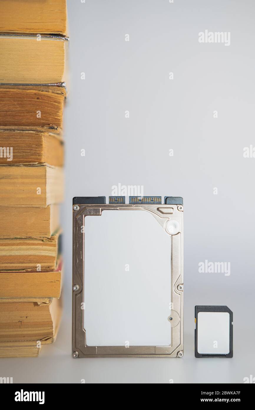 Pila di libri, unità disco rigido e scheda di memoria. Dati di storage, informazioni compresse, concetto digitale e analogico Foto Stock