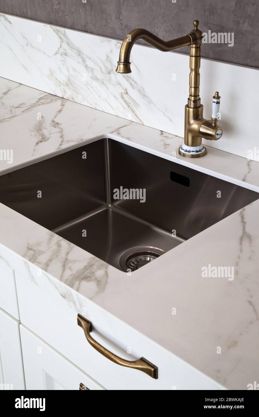 Interni di lussuosa cucina moderna e lavello e rubinetto in acciaio inox Foto Stock