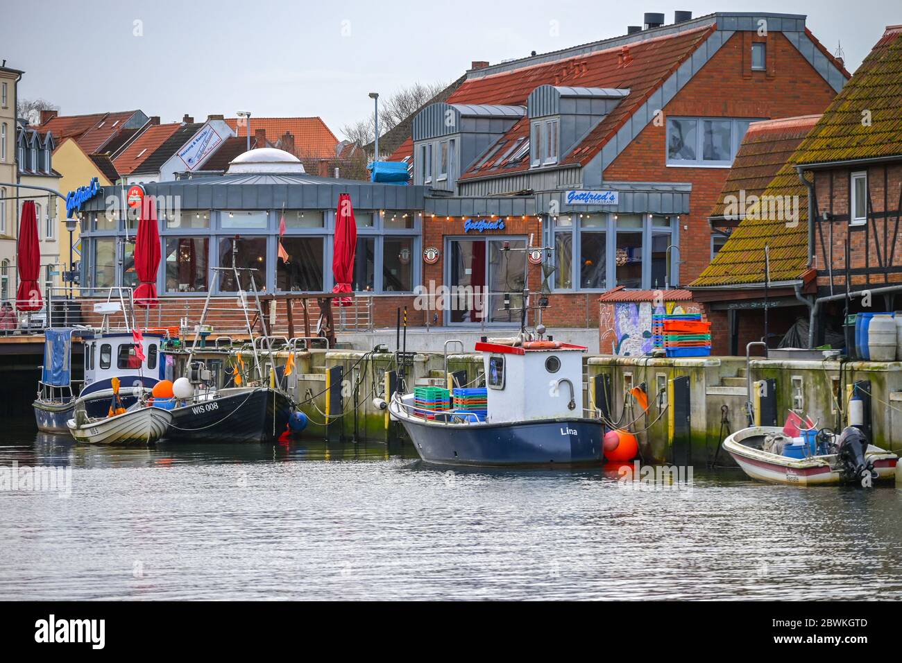 WISMAR, GERMANIA, 2 FEBBRAIO 2020: Colorate barche da pesca e ristoranti nel vecchio porto della città anseatica di Wismar, una delle attrazioni turistiche più importanti Foto Stock