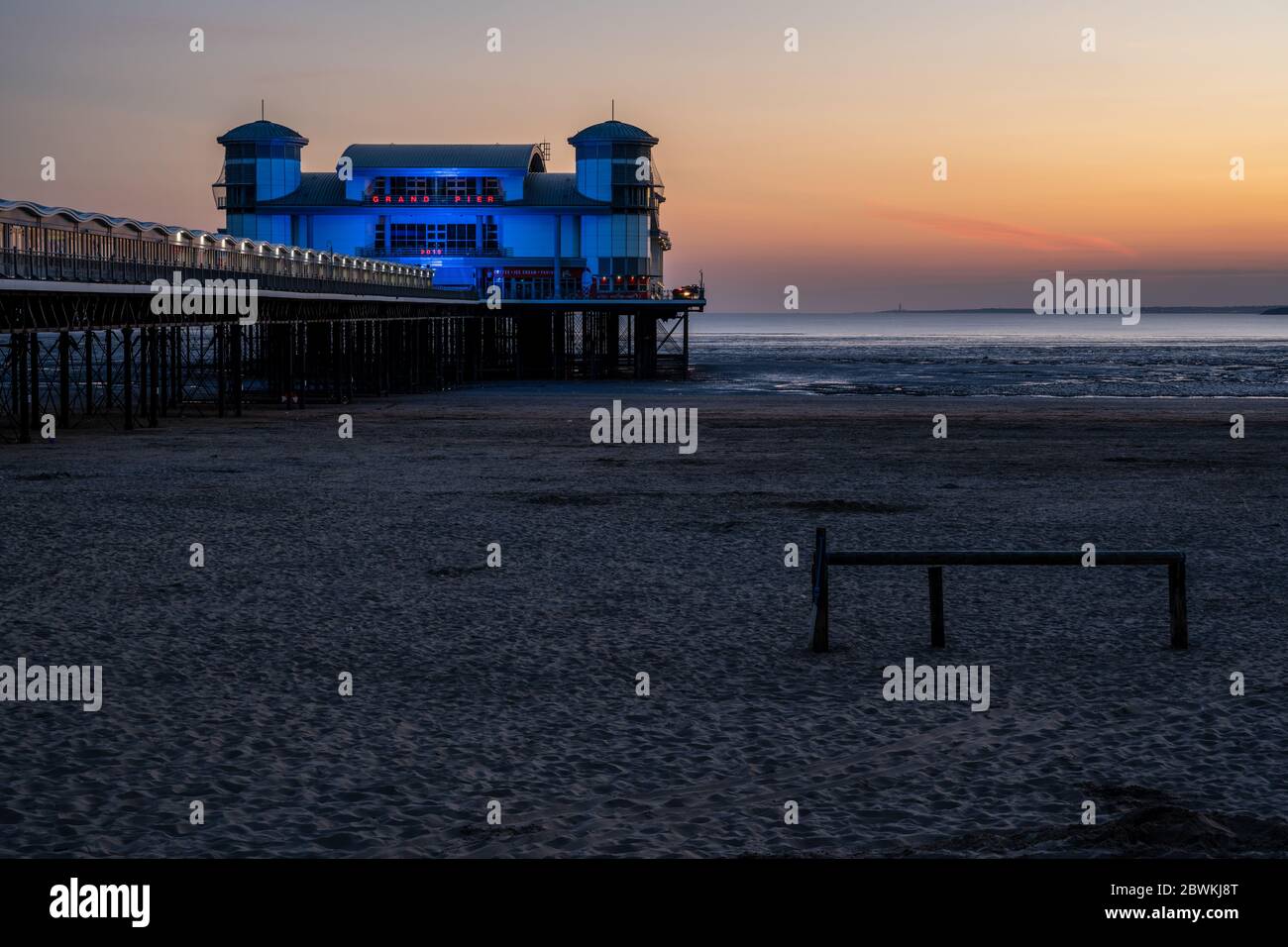 Weston-Super-Mare, Inghilterra, Regno Unito - 31 maggio 2020: Il sole tramonta dietro il moderno Grand Pier di Wester-Super-Mare, con il Galles del Sud a distanza Foto Stock