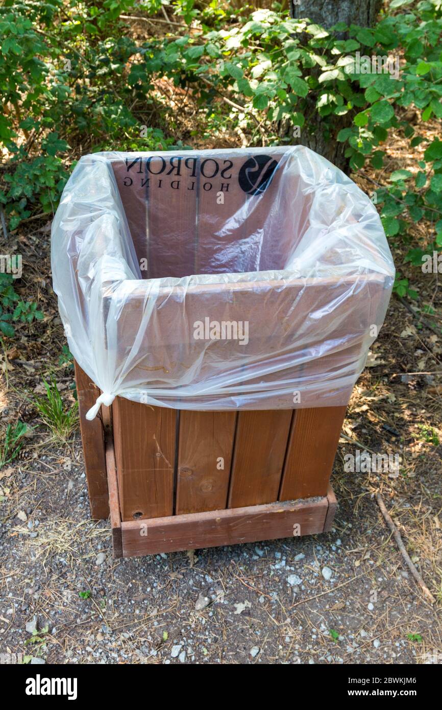 Sacco di plastica (Sopron Holding) in bidone di legno spazzatura in foresta, Sopron, Ungheria Foto Stock