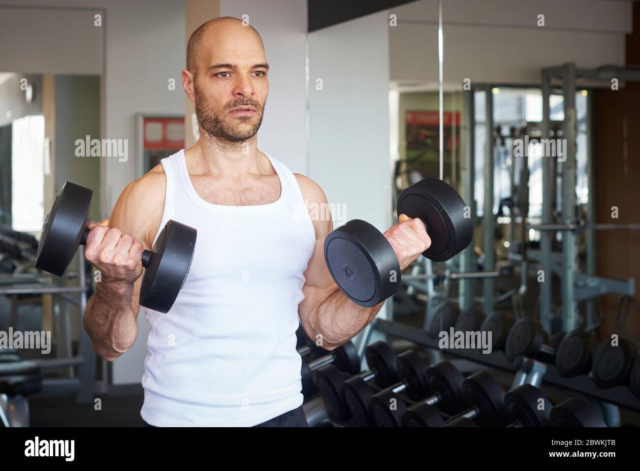 Colpo di uomo in palestra facendo esercizi con manubri per creare più  muscoloso Foto stock - Alamy