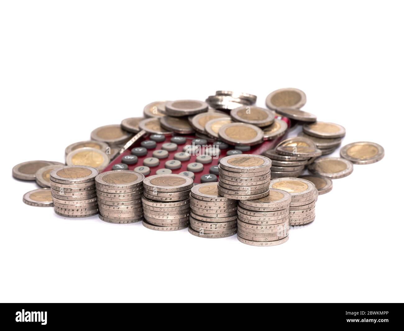 Monete metalliche in euro stack di denaro e delle singole monete sparse su una calcolatrice tascabile Foto Stock