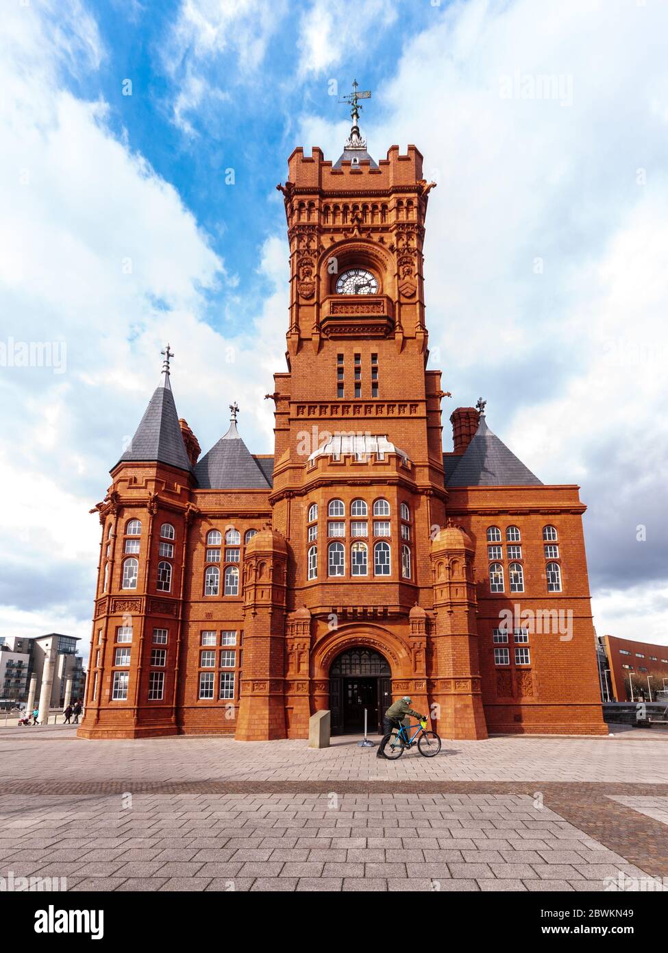 Cardiff, Galles, Regno Unito - 17 marzo 2013: Un ciclista passa accanto all'edificio vittoriano Pierhead nella baia di Cardiff. Foto Stock