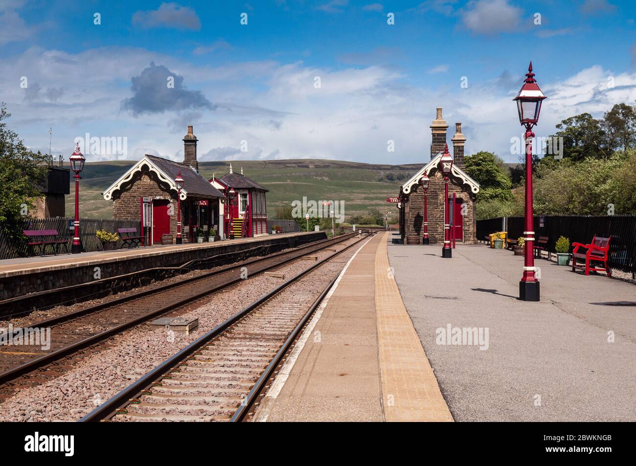 Garsdale, Inghilterra, Regno Unito - 24 maggio 2011: Il sole splende sulle sale d'attesa tradizionali e sulla scatola di segnale della stazione di Garsdale sulla ferrovia Settle-Carlisle in Foto Stock