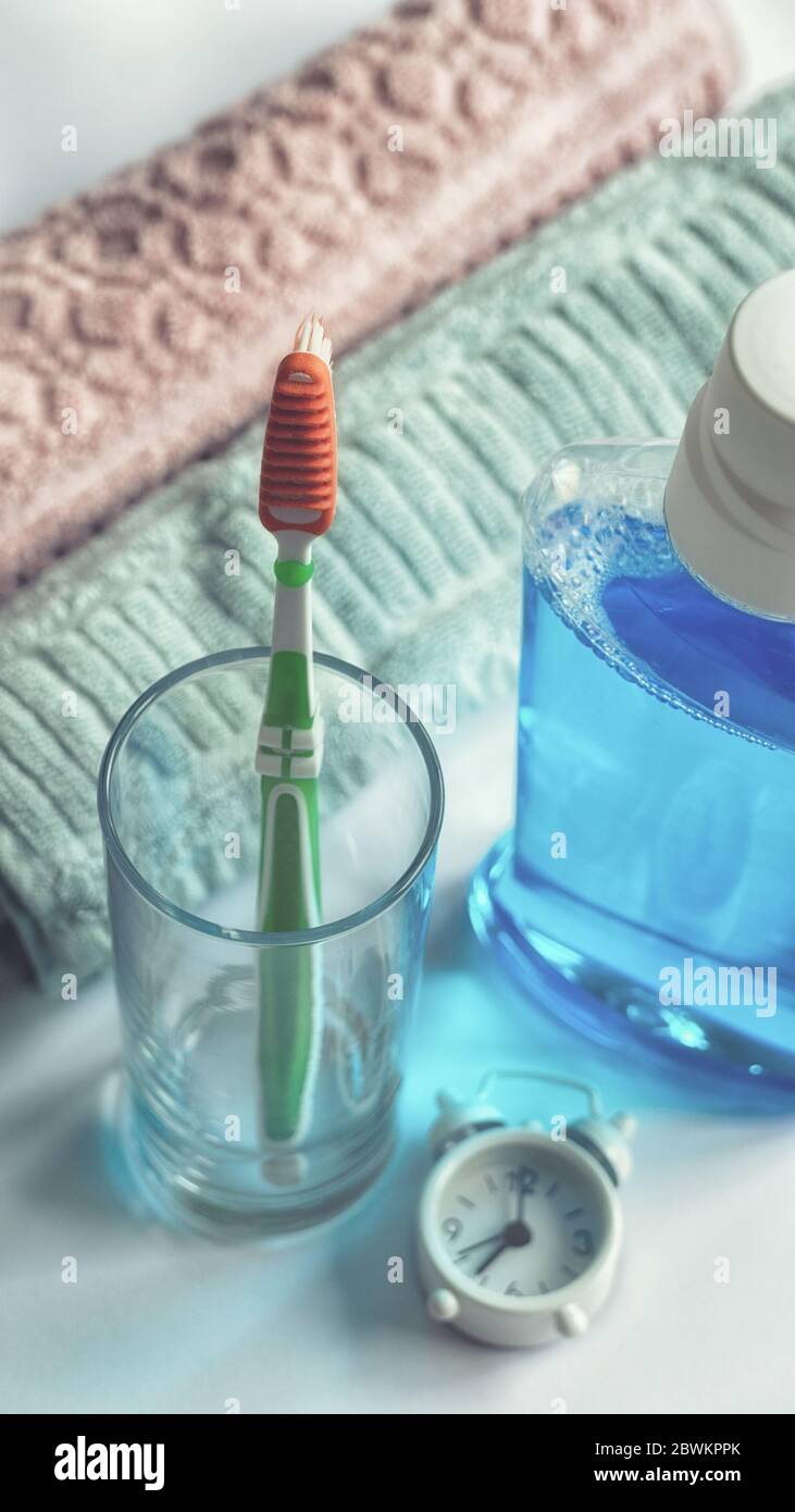 Primo piano di spazzolino e asciugamani per il lavaggio del bocca in bagno igiene del mattino routine dentale salute concetto educativo Foto Stock