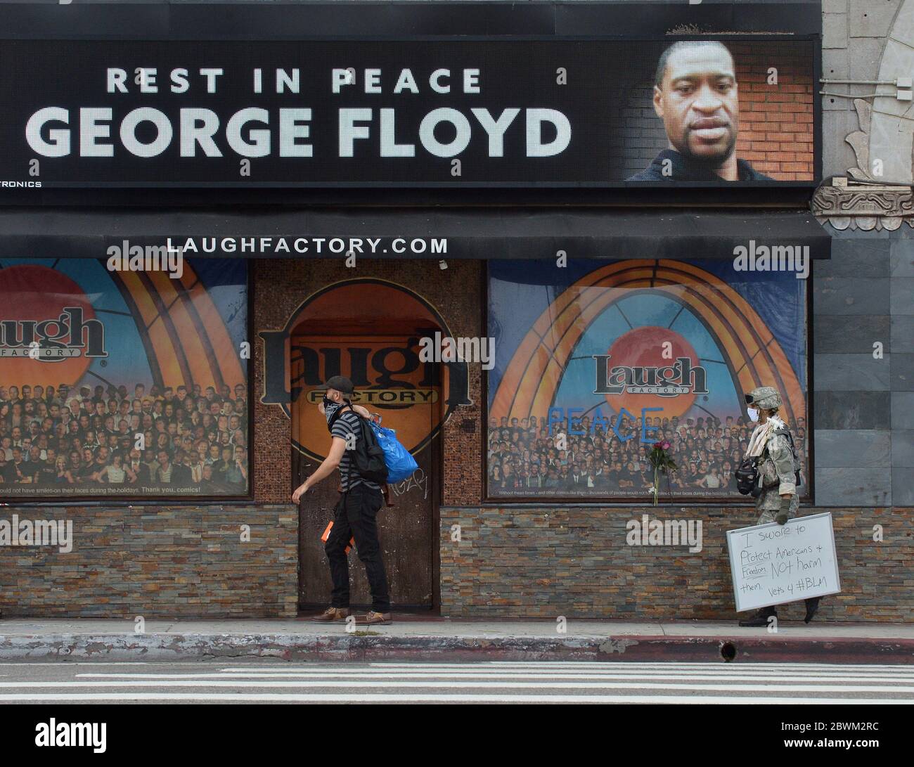 Los Angeles, Stati Uniti. 01 Giugno 2020. Un veterano cammina davanti alla fabbrica della risata con una foto di George Floyd dove centinaia di persone si sono riunite per onorare la memoria di Floyd a Los Angeles lunedì 1 giugno 2020. Proteste pacifiche a Hollywood e Van Nuys sono state marziate quando decine di saccheggiatori, molti dei quali sembravano non essere collegati alle manifestazioni, hanno fatto irruzione nelle aziende vicine. Foto di Jim Ruymen/UPI Credit: UPI/Alamy Live News Foto Stock