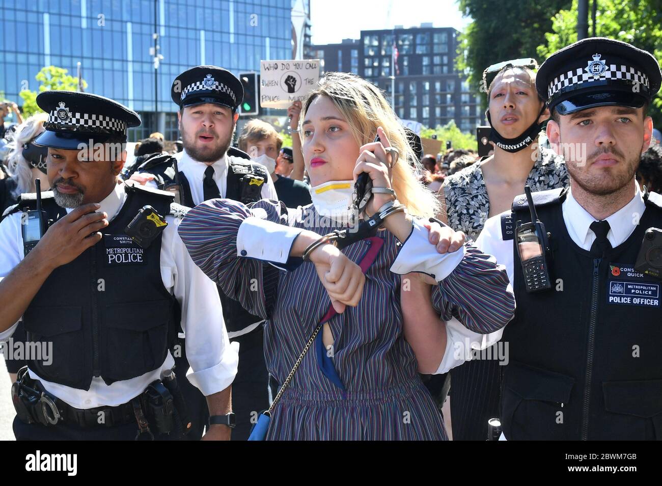 Una donna è guidata dalla polizia durante una protesta contro la questione Black Lives fuori dall'ambasciata degli Stati Uniti a Londra. La protesta segue la morte di George Floyd a Minneapolis, USA, questa settimana, che ha visto un ufficiale di polizia accusato di omicidio di terzo grado. Foto Stock