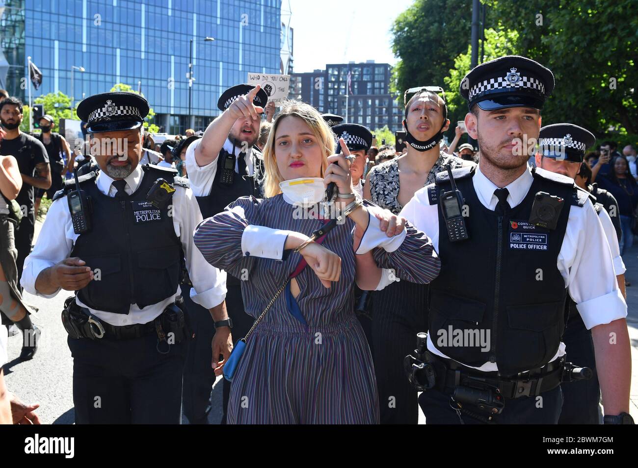 Una donna è guidata dalla polizia durante una protesta contro la questione Black Lives fuori dall'ambasciata degli Stati Uniti a Londra. La protesta segue la morte di George Floyd a Minneapolis, USA, questa settimana, che ha visto un ufficiale di polizia accusato di omicidio di terzo grado. Foto Stock
