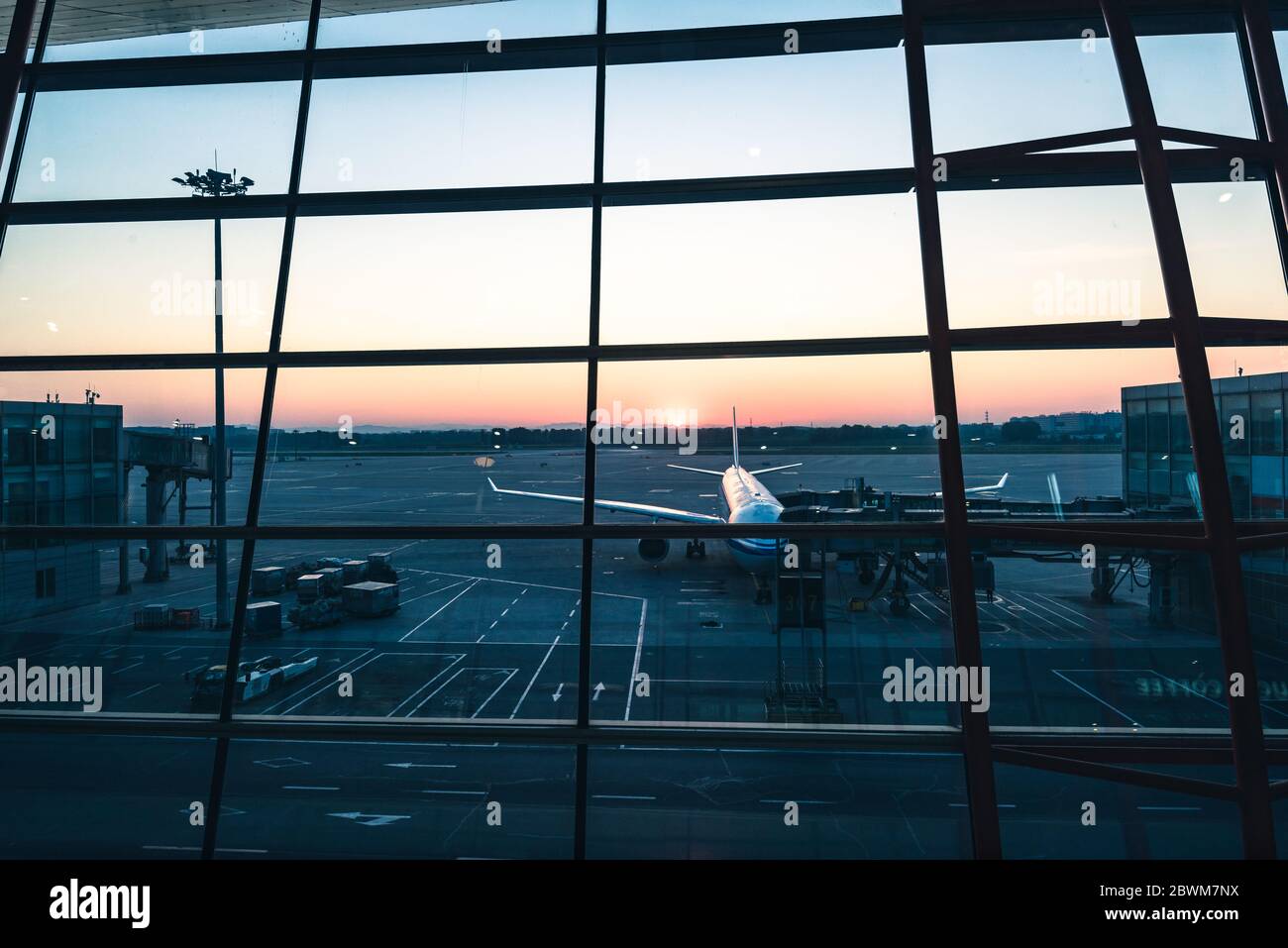 aereo al parcheggio vista grembiule dalla finestra della sala d'attesa del terminal aereo all'alba Foto Stock