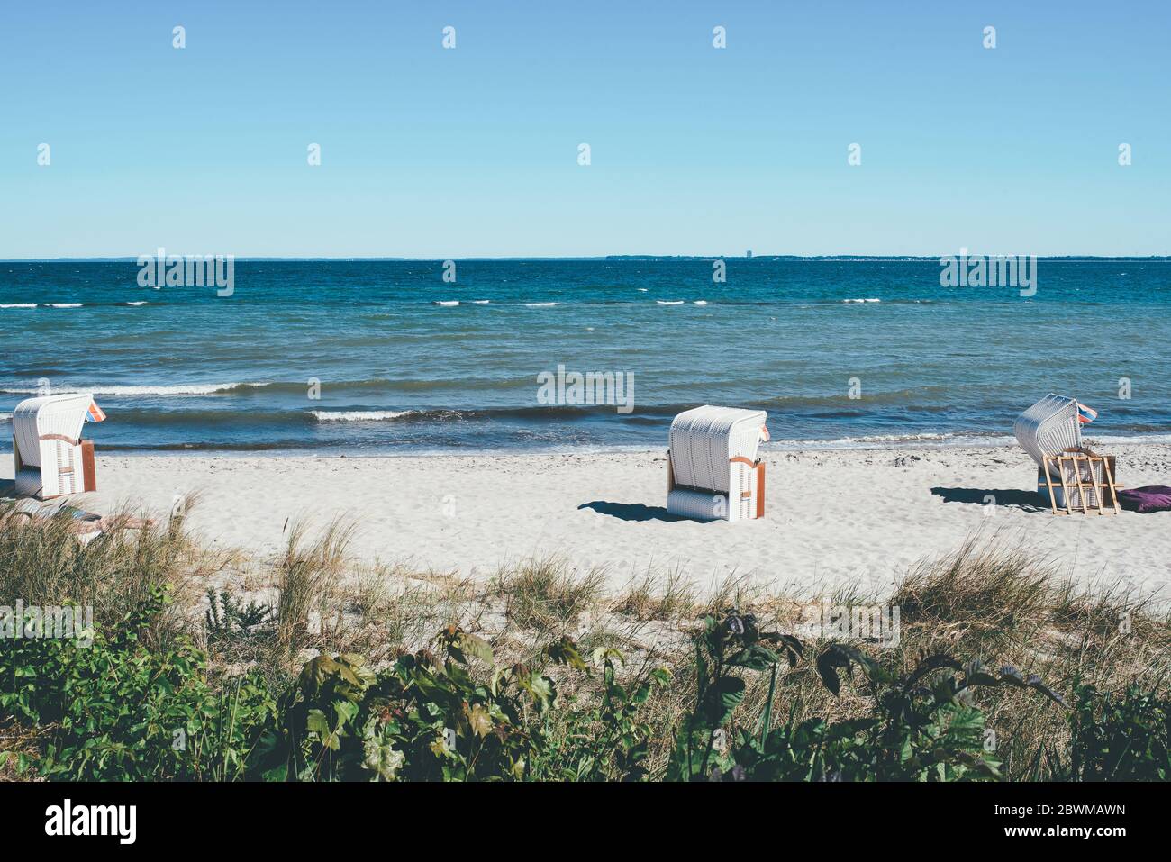 sdraio a baldacchino sulla spiaggia di sabbia contro il mar baltico e cielo blu chiaro Foto Stock