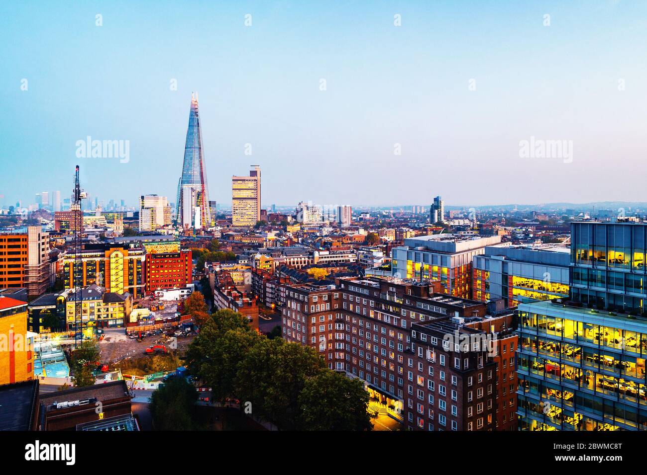 Londra, Regno Unito. Vista aerea dello skyline di Londra, Inghilterra, Regno Unito con famosi grattacieli moderni e altri edifici illuminati durante il tramonto Foto Stock