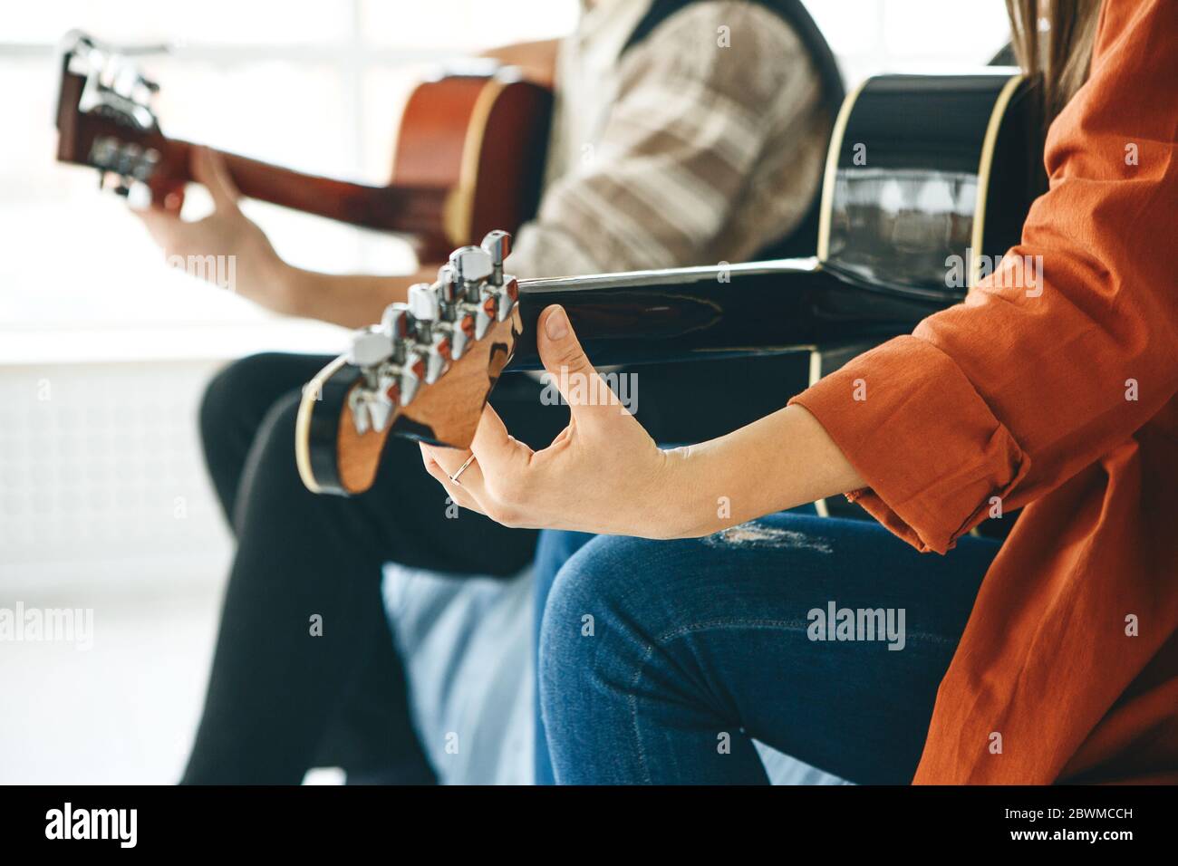 Imparare a suonare la chitarra. L'insegnante spiega allo studente le basi per suonare la chitarra. Lezioni individuali di scuola domestica o extracurricolare. Foto Stock