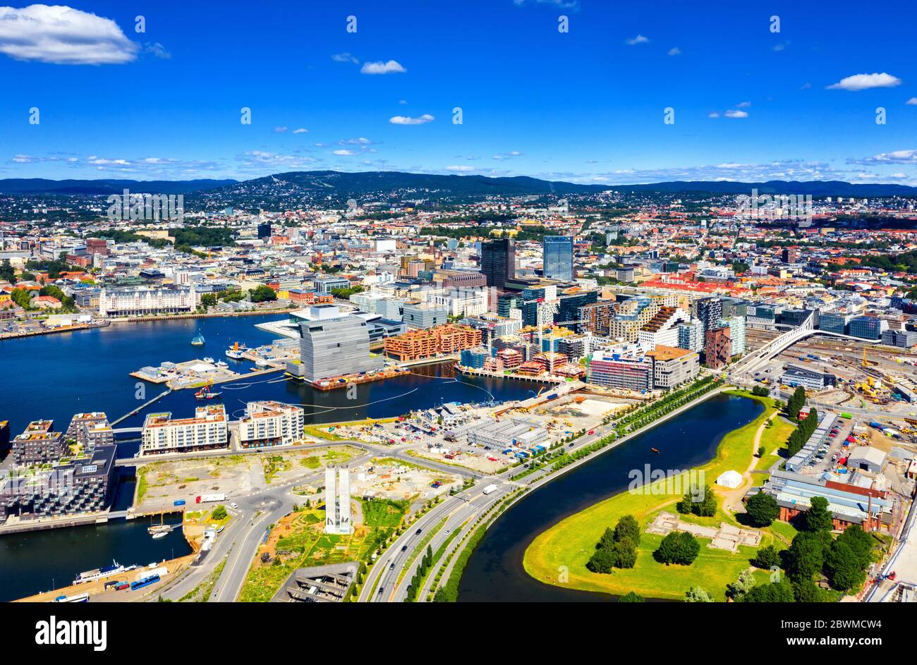 Oslo, Norvegia. Vista aerea della zona del Sentrum di Oslo, Norvegia, con edifici con codice a barre e il fiume Akerselva. Cantiere con cielo blu durante una su Foto Stock