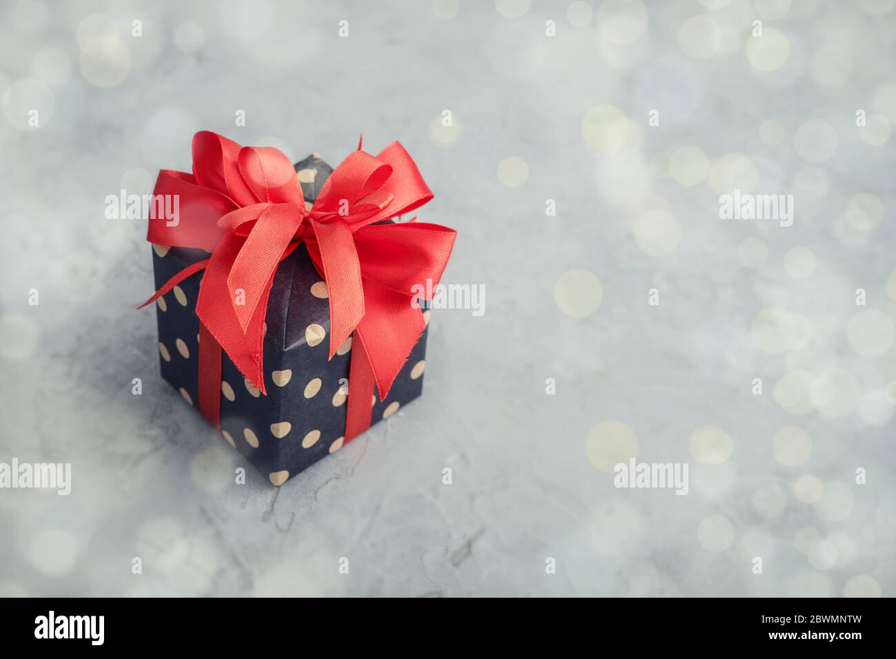 Confezione regalo Polka dot con nastro rosso su fondo grigio Foto Stock