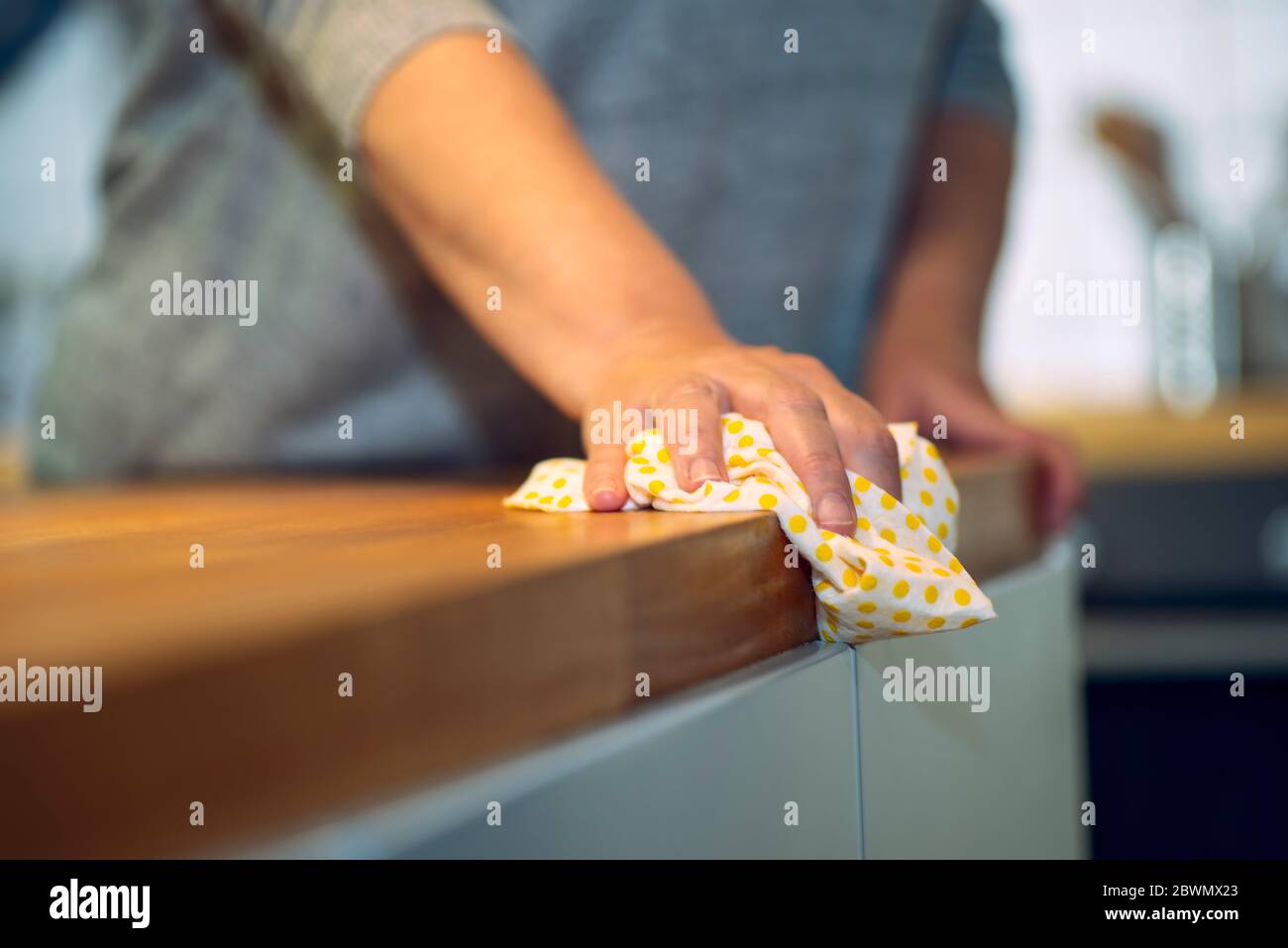 La persona si asciuga con un panno sopra un piano di lavoro in una cucina Foto Stock