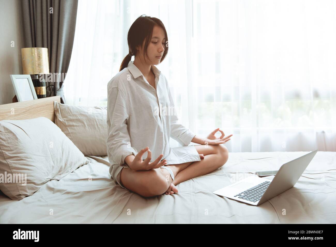 Asian Girl teen fare Yoga pratica casa imparare online da internet trainer lezione sito web durante soggiorno casa auto-quarantena Foto Stock