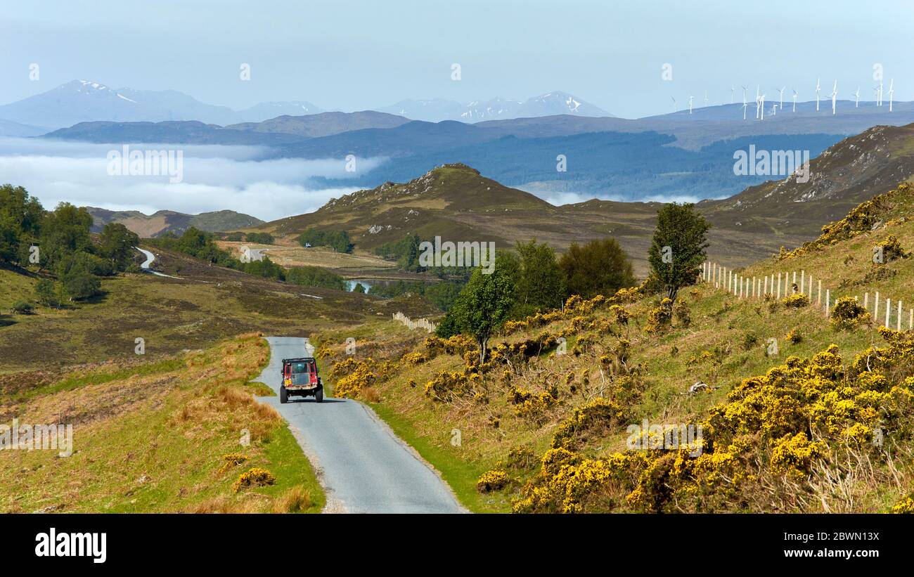 LA STRADA MILITARE DEL GENERAL WADE SUL LATO SUD DI LOCH NESS SCOTLAND LOCH, INVERSIONE DELLE NUBI DEL MATTINO PRESTO E LA GAMMA BEN NEVIS E LE TURBINE EOLICHE NEL D. Foto Stock