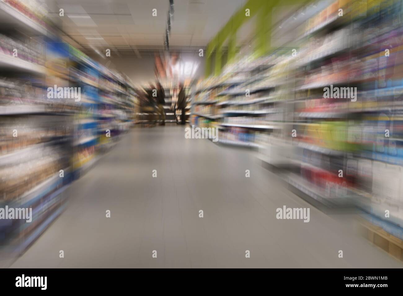 shopping nel supermercato durante il coprifuoco di crisi del coronavirus, poche persone tra gli scaffali completi, zoom motion blur Foto Stock