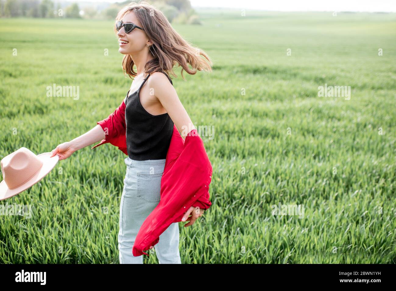 Ritratto di una donna elegante e spensierata sul verde godendo della natura in primavera. Concetto di benessere e stile di vita spensierato sulla natura Foto Stock