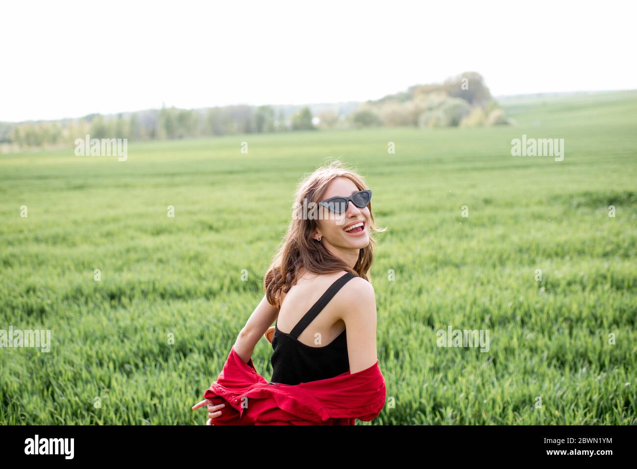 Ritratto di una donna elegante e spensierata sul verde godendo della natura in primavera. Concetto di benessere e stile di vita spensierato sulla natura Foto Stock