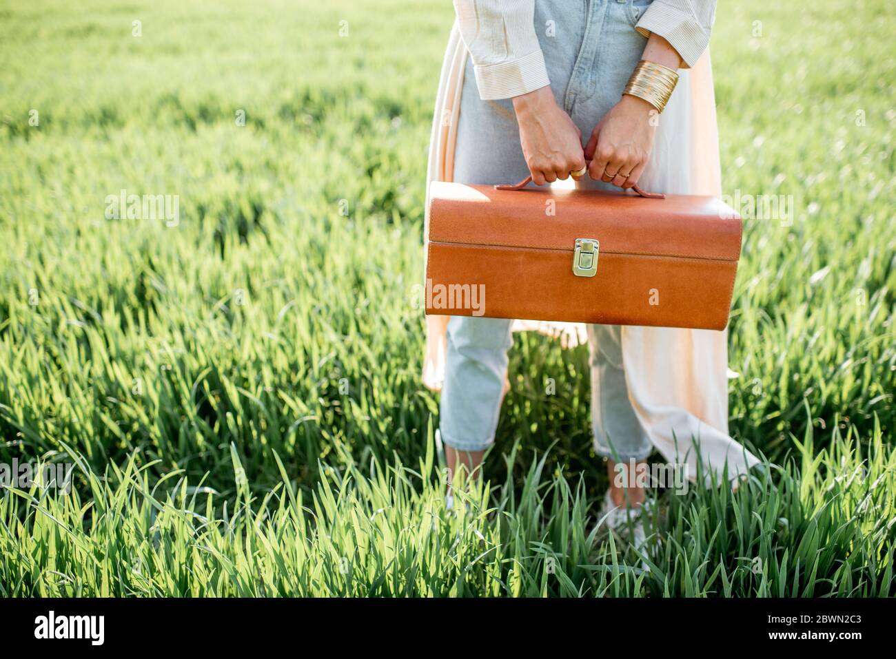 Donna con bella borsa sul campo verde Foto Stock