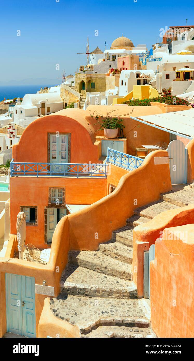 Vista iconica di edifici colorati e dei mulini a vento di Oia costruiti sul bordo della caldera di Santorini Foto Stock