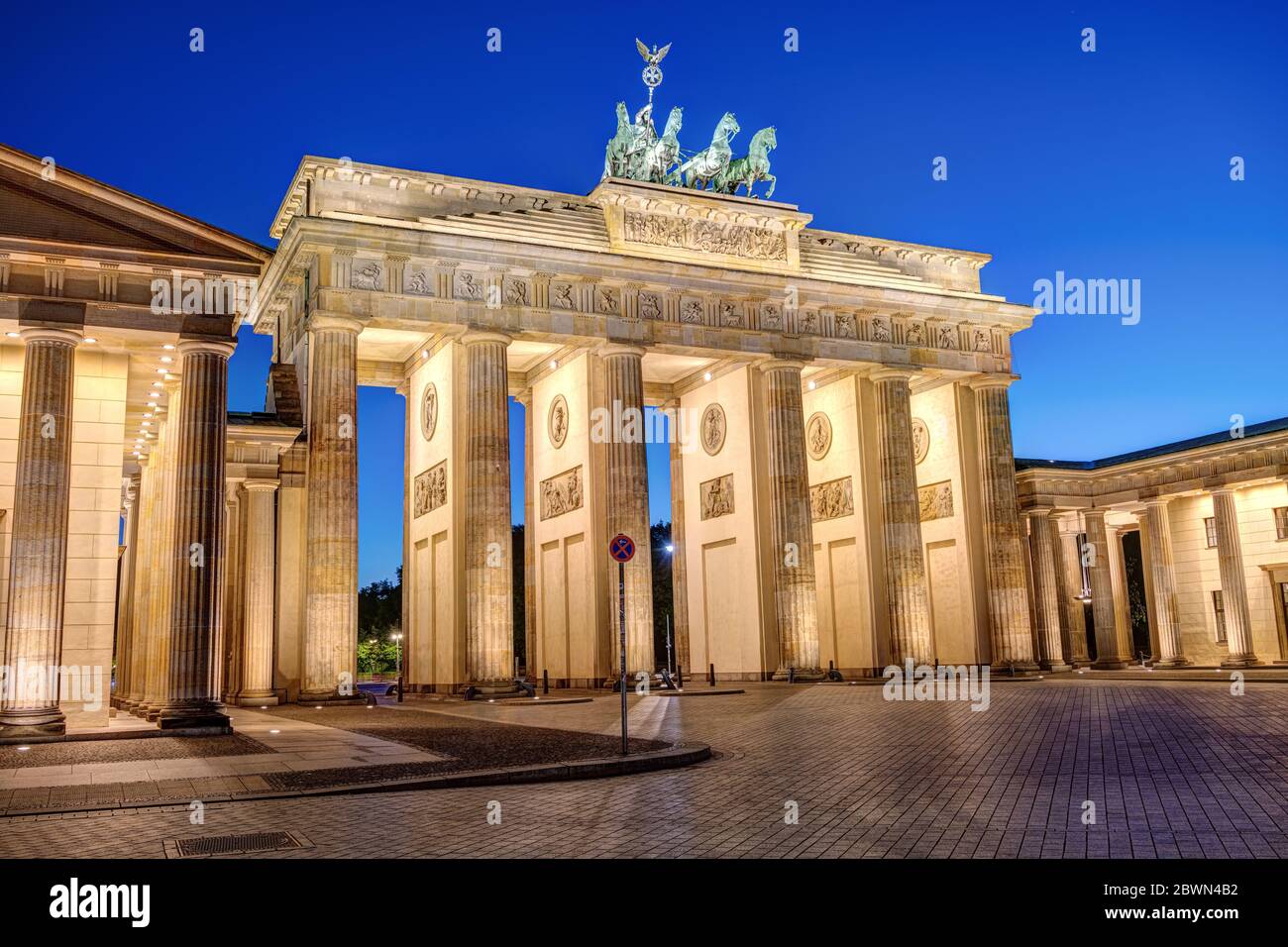 La famosa porta di Brandeburgo illuminata a Berlino all'ora blu senza persone Foto Stock