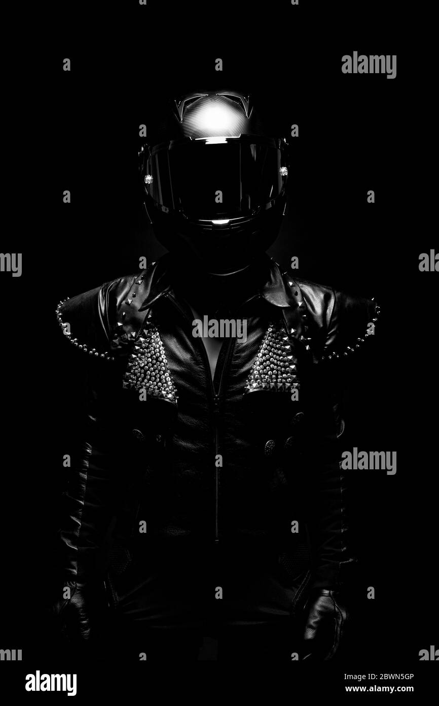 Ritratto di una giovane biker femminile con giacca in pelle con borchie e casco nero Foto Stock