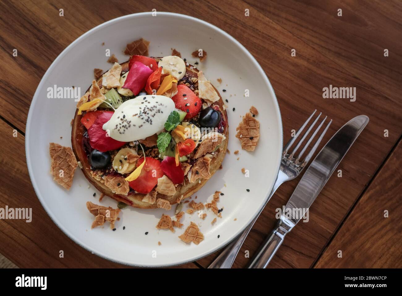 Pancake con banana, kiwi, fragole e gelato su un piatto, vista dall'alto Foto Stock