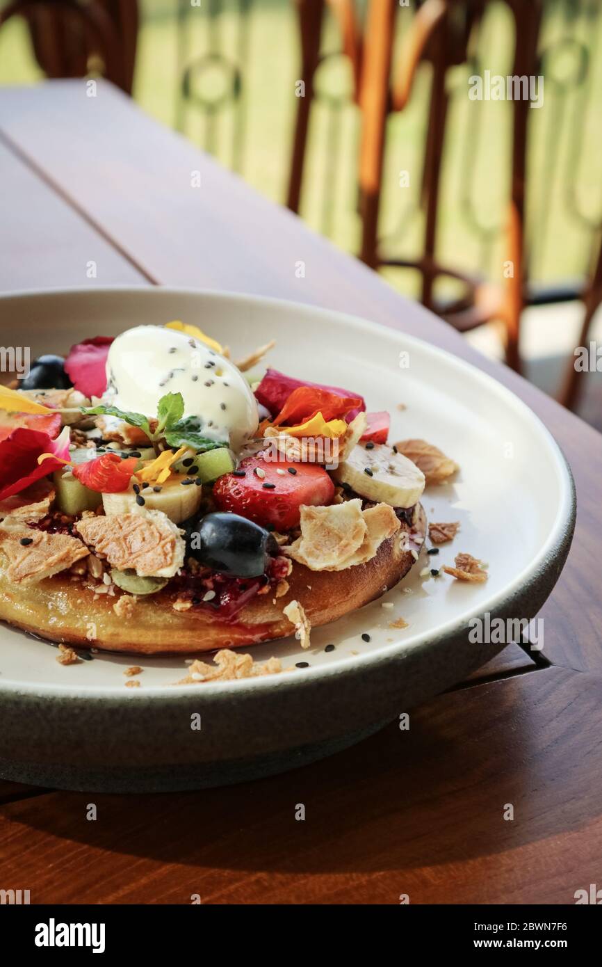 Pancake con banana, kiwi, fragole e gelato su un piatto, guardaroba Foto Stock