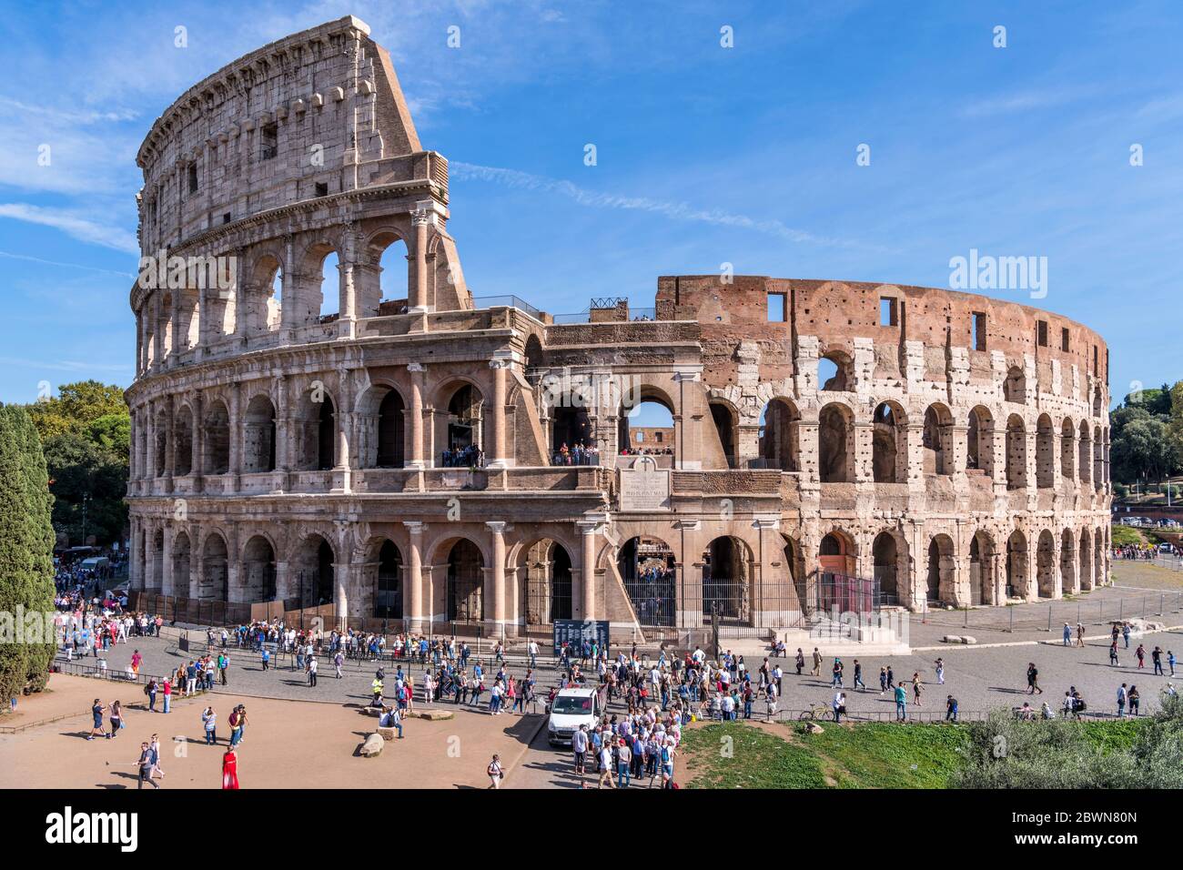 Colosseo - una vista completa del lato ovest del Colosseo e dell'affollata Piazza del Colosseo in un pomeriggio di sole a ottobre. Roma, Italia. Foto Stock