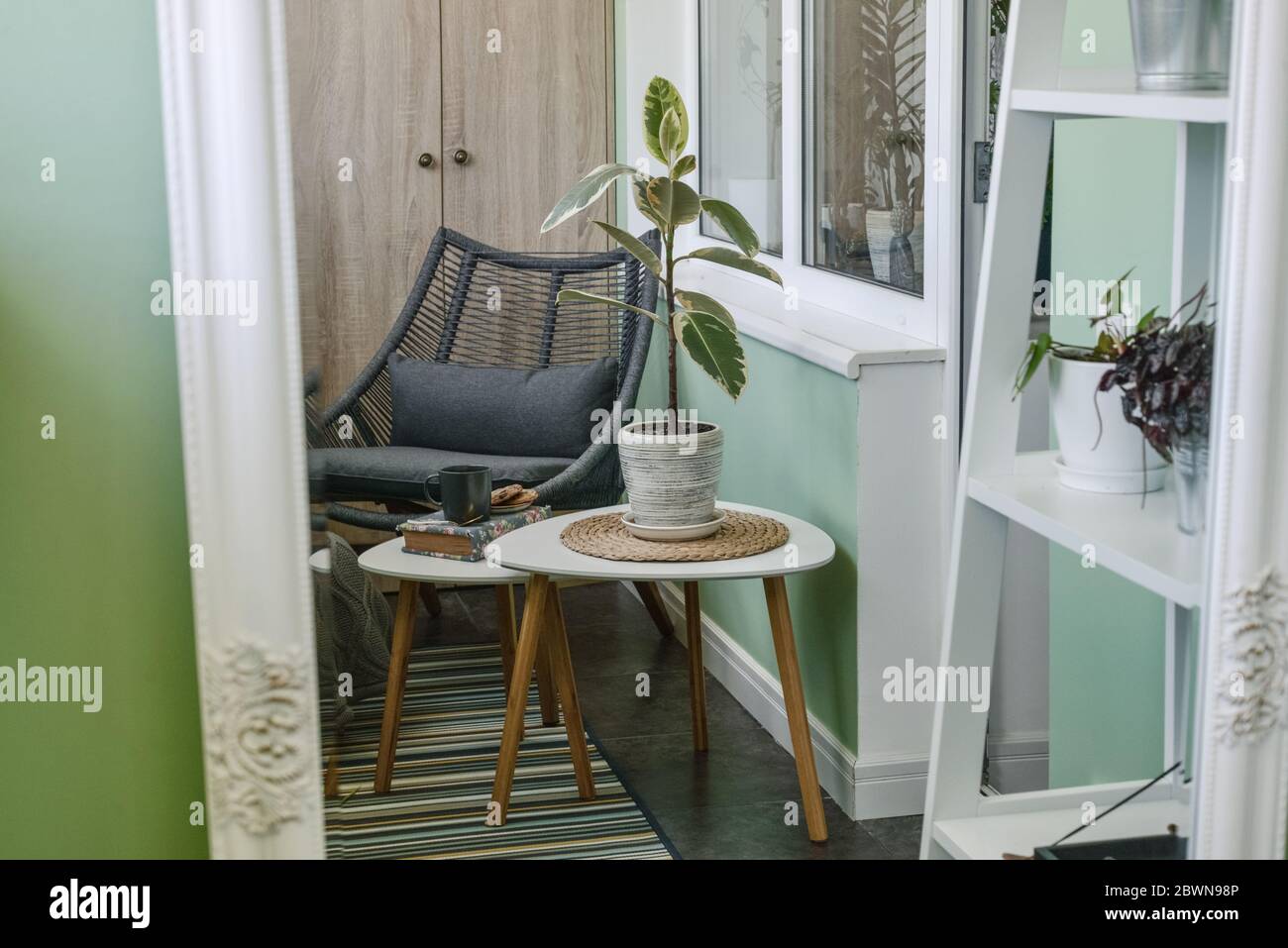 Ufficio moderno spazio interno con piante, tavolo in metallo, tappeto beige  e muro grigio Foto stock - Alamy