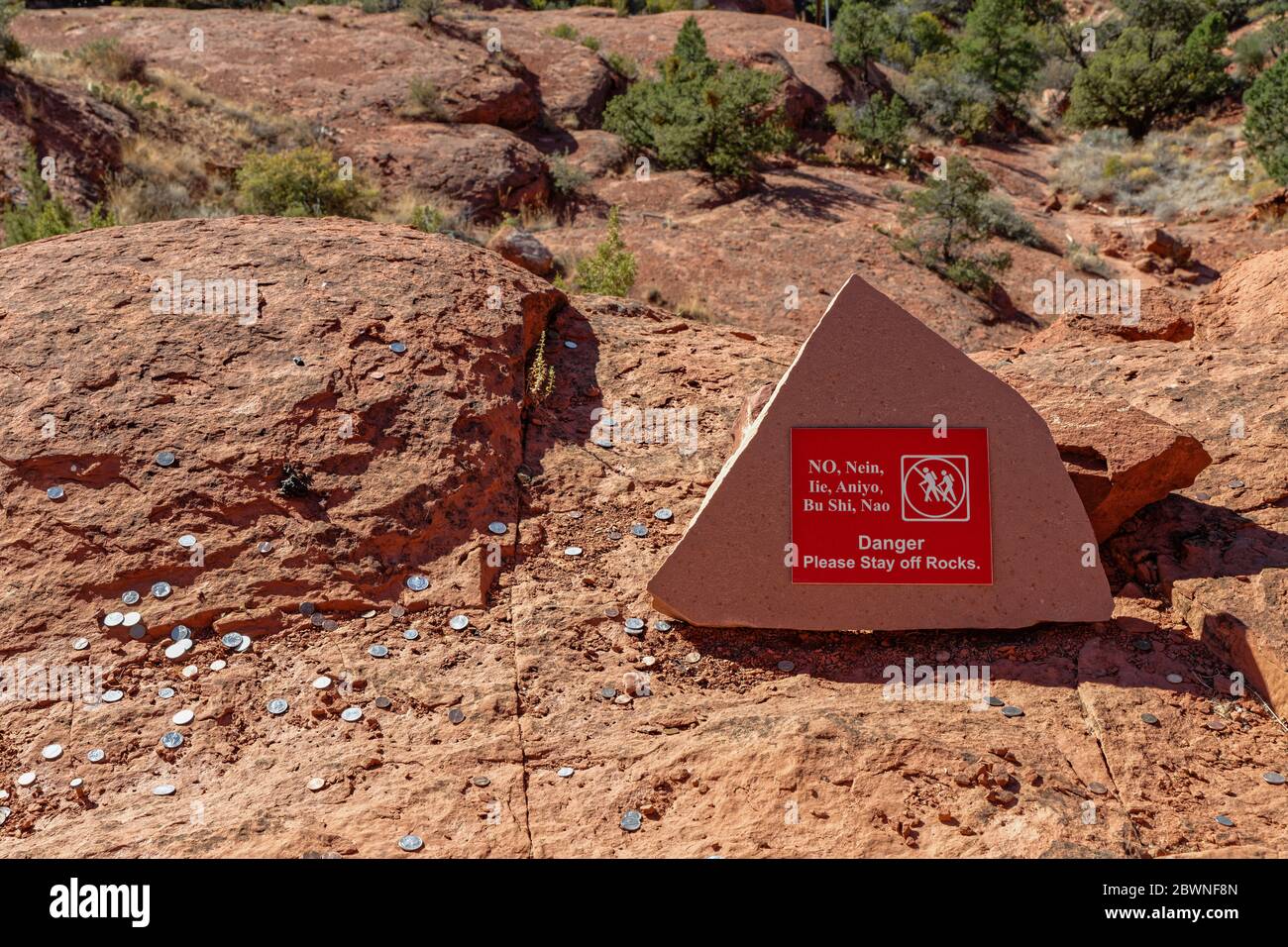 Cartello di pericolo sulle rocce nella zona di Sedona senza possibilità di escursioni in diverse lingue, tra cui cinese, giapponese, coreano e tedesco, nonché gettata moneta Foto Stock