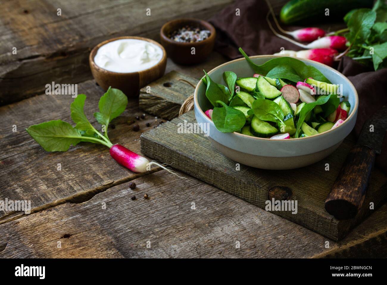 Cibo vegano sano. Insalata vegetariana di spinaci, rafano e cetrioli freschi. Spazio di copia. Foto Stock