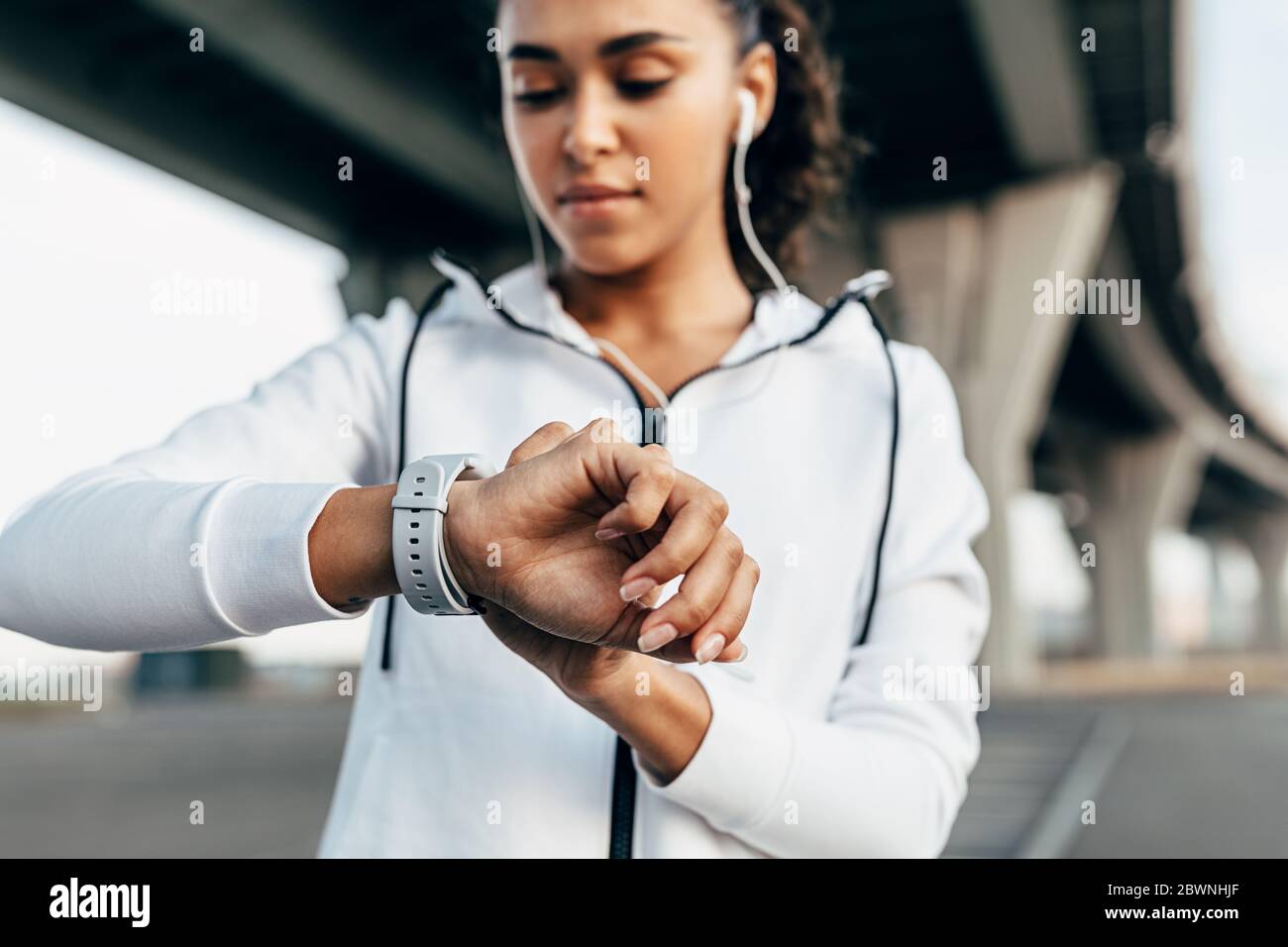 Primo piano della mano della donna con un orologio intelligente. Dopo l'esercizio, fit woman che guarda sull'activity tracker. Foto Stock