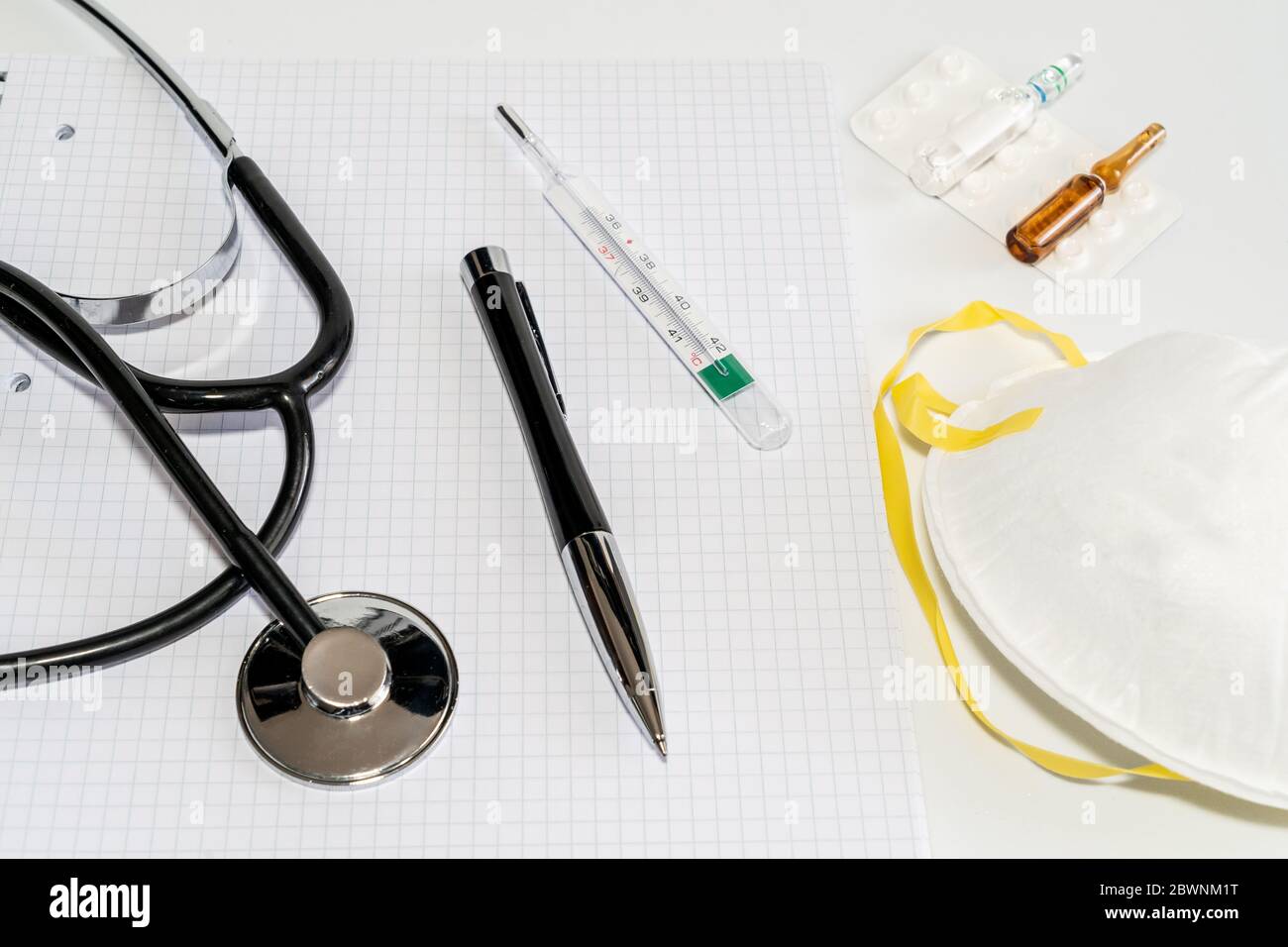 Maschere mediche con elastico, termometro, medicina e stetoscopio, isolate su sfondo bianco. Concetto sanitario e medico. Foto di alta qualità Foto Stock