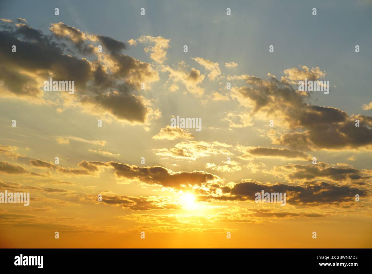 Cielo tramonto con nuvole e travi soleggiate. Cielo tramonto sfondo. Foto Stock