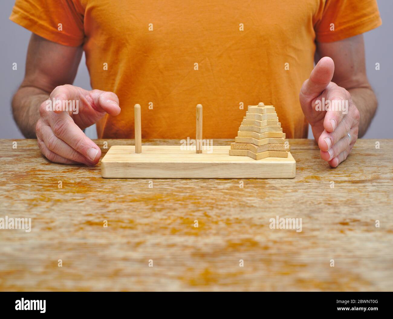 Uomo circa per tentare la Torre di Hanoi puzzle matematico Foto Stock