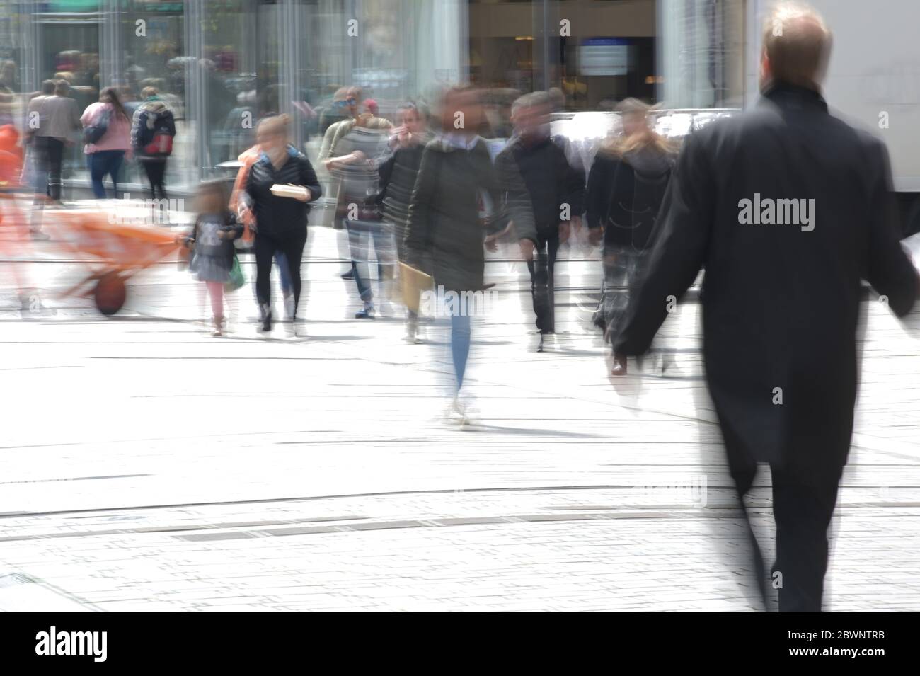 Persone nella zona pedonale dello shopping, movimento sfocato attraverso esposizione a lungo termine, pericoloso concetto di vita della città durante la pandemia coronavirus, spazio copia Foto Stock