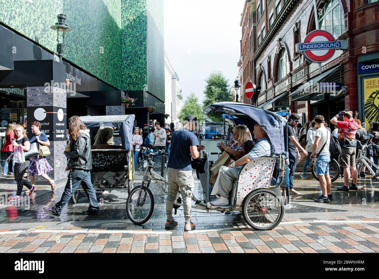 Ecotaxi, pedicab o risciò in bicicletta urbana con cavaliere e passanti Covent Garden, Londra Centrale, Inghilterra Gran Bretagna Foto Stock