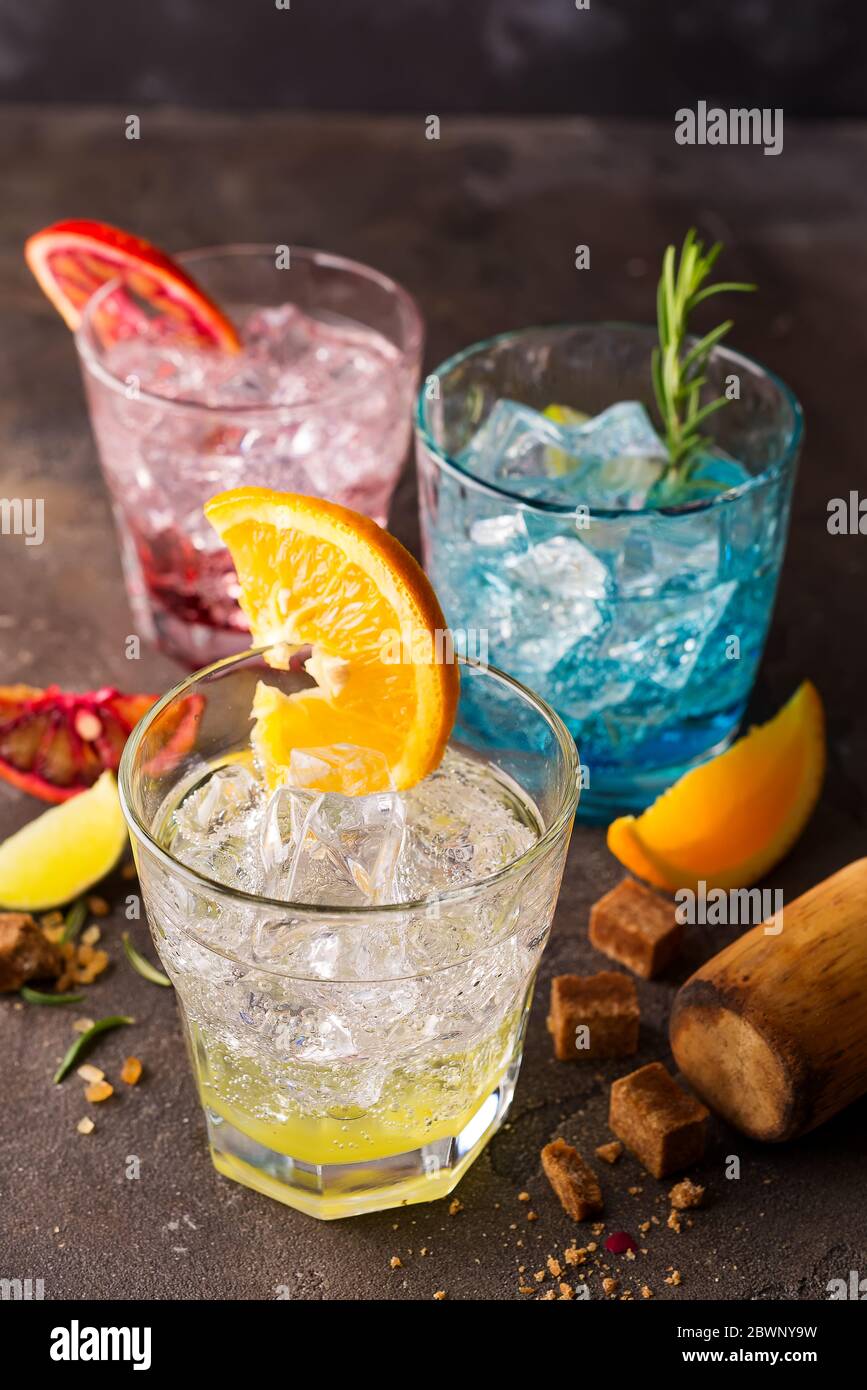 Set di cocktail colorati con frutta ed erbe, zucchero di canna su fondo di pietra Foto Stock