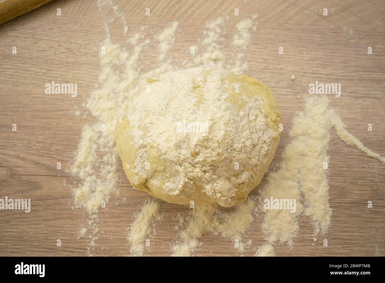 Preparazione per la pasta per pizza su tavola di legno con farina Foto Stock