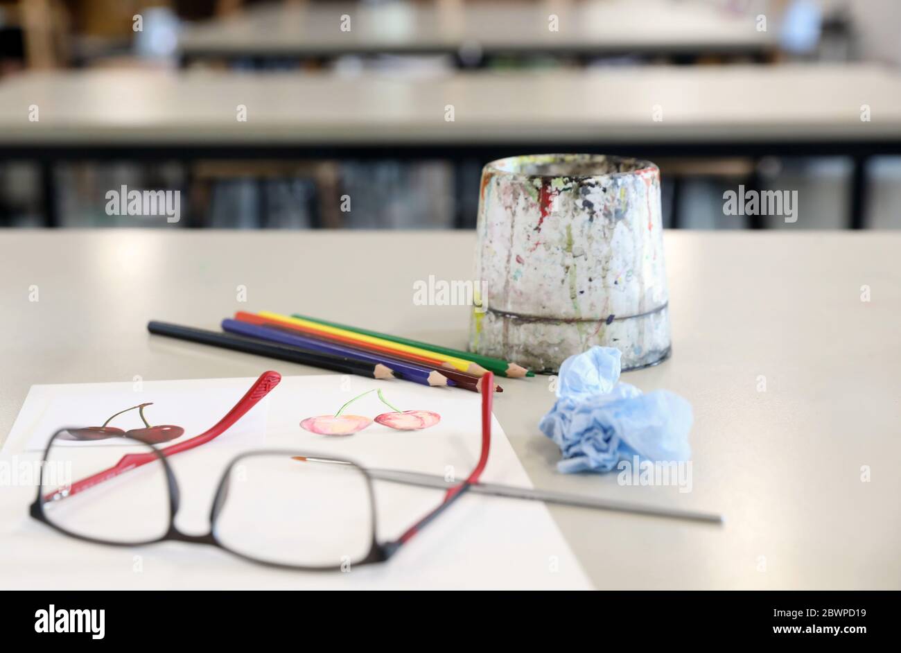 attrezzature per arti visive per la dimostrazione in classe da parte dell'insegnante. Le vernici acquose pennellano carta e matite su una scrivania o un tavolo nella sala d'arte Foto Stock