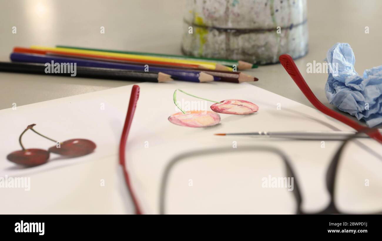 attrezzature per arti visive per la dimostrazione in classe da parte dell'insegnante. Le vernici acquose pennellano carta e matite su una scrivania o un tavolo nella sala d'arte Foto Stock